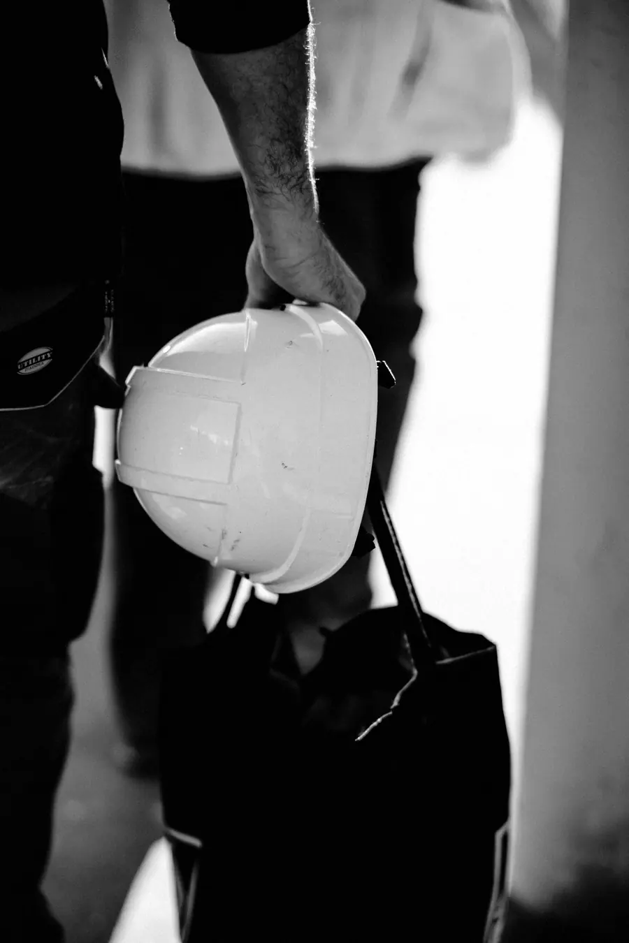 Handwerker mit Schutzhelm und Tasche auf dem Weg zum neuen Job